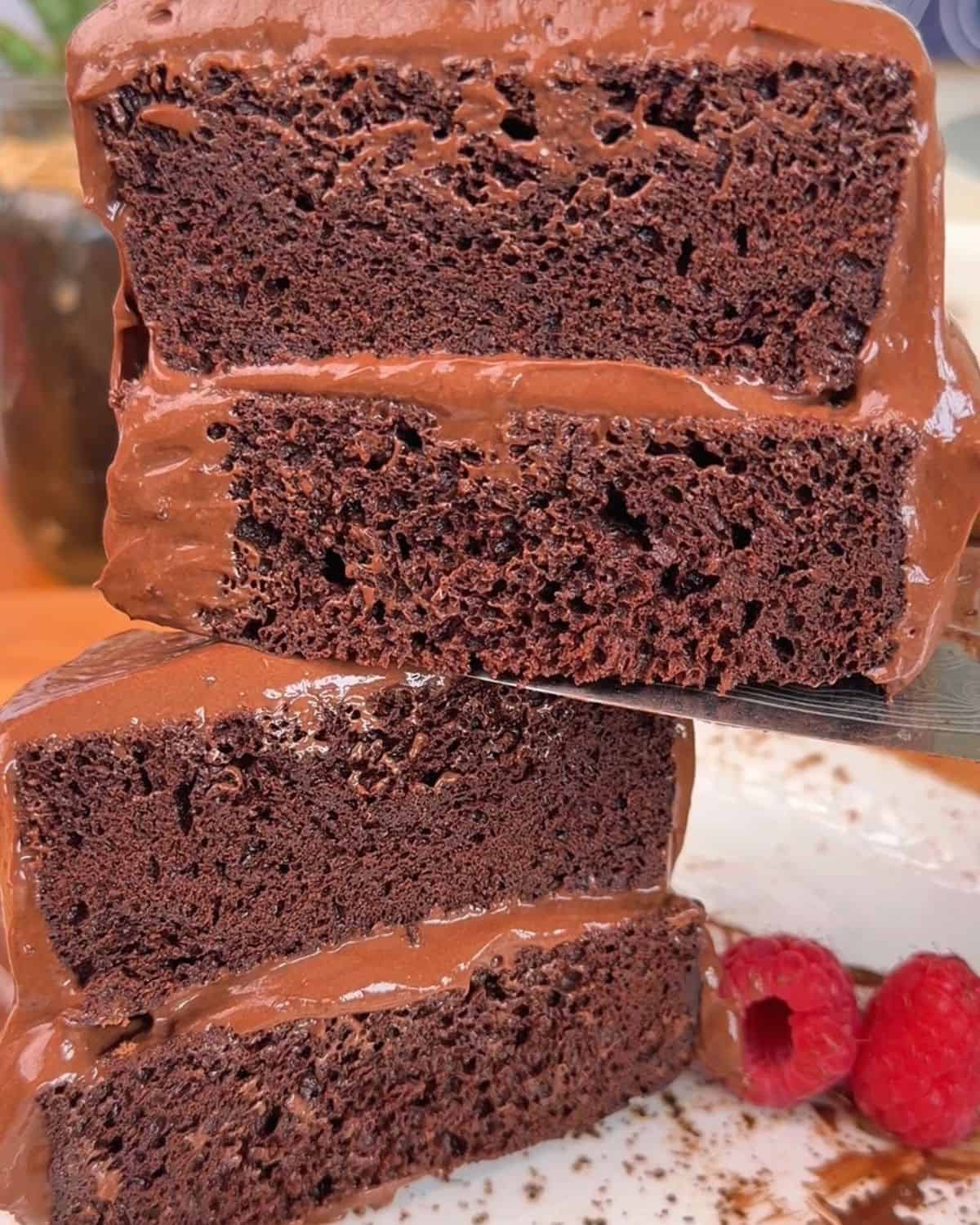 two slices of high protein chocolate cake, with a fudgy chocolate frosting layer inside