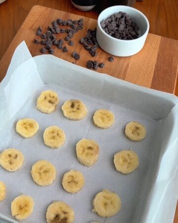 sliced bananas on a cookie sheet for the making of caramelized banana chocolate chunk blondies