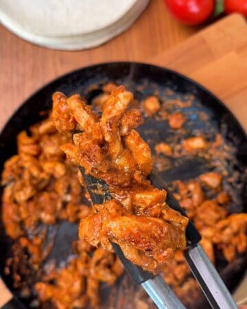 Chicken being cooked in a pan, so it's juicy and flavorful for a chicken shawarma wrap