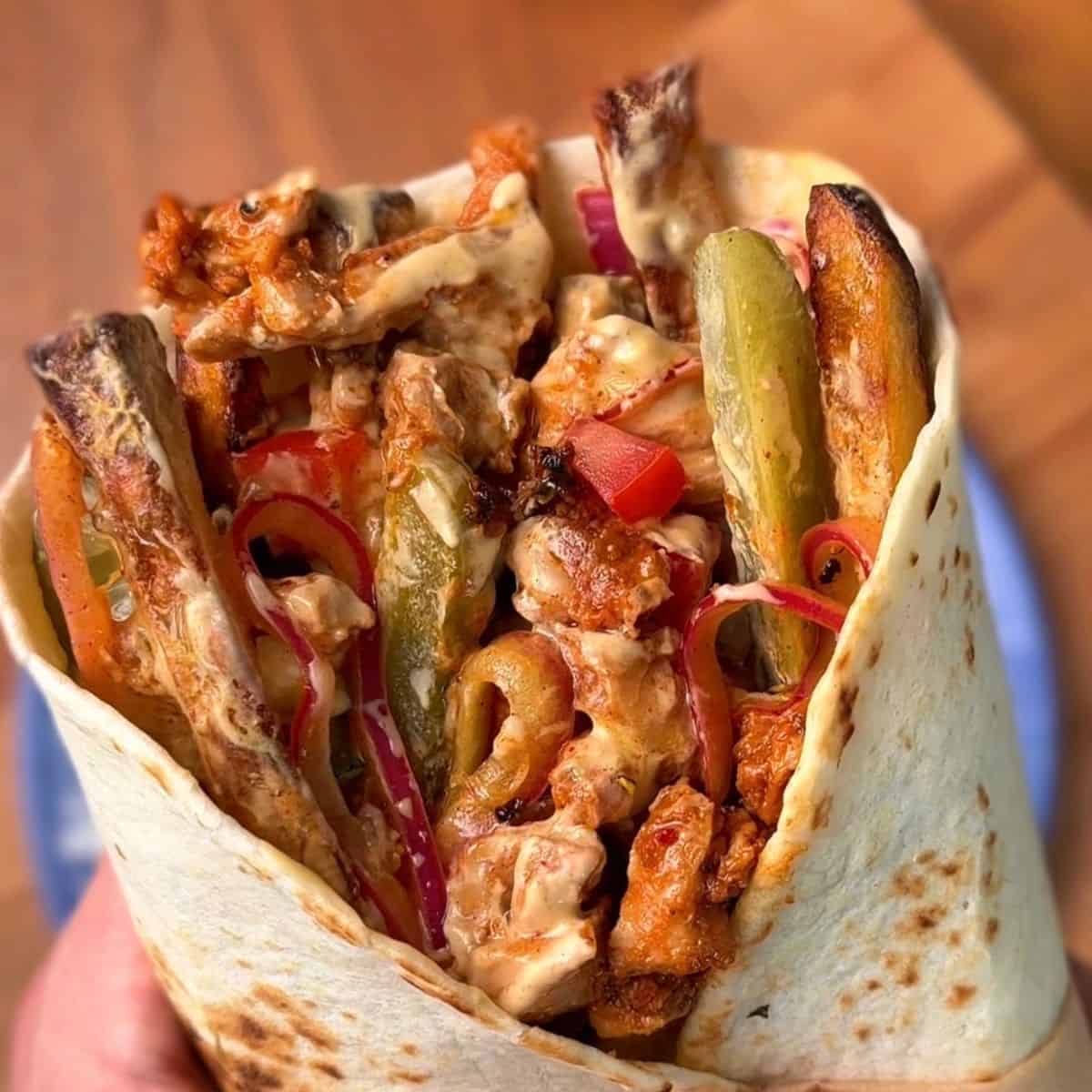 a juicy, flavorful chicken shawarma wrap with a garlicky yogurt sauce and fries