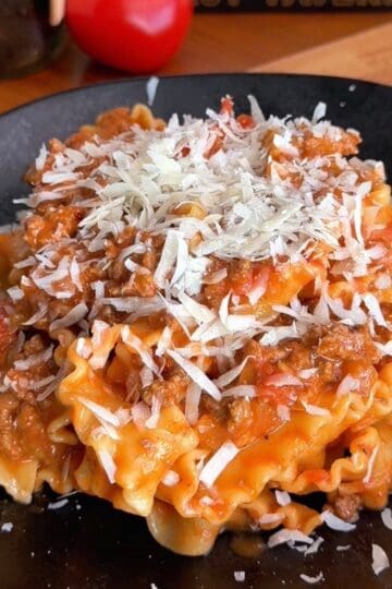 Delicious cheesy beef lasagna with rich tomato sauce and melted cheese on top.