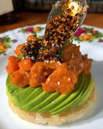 mini waffle made from rice, topped with avocado, salmon, green onion, chili oil