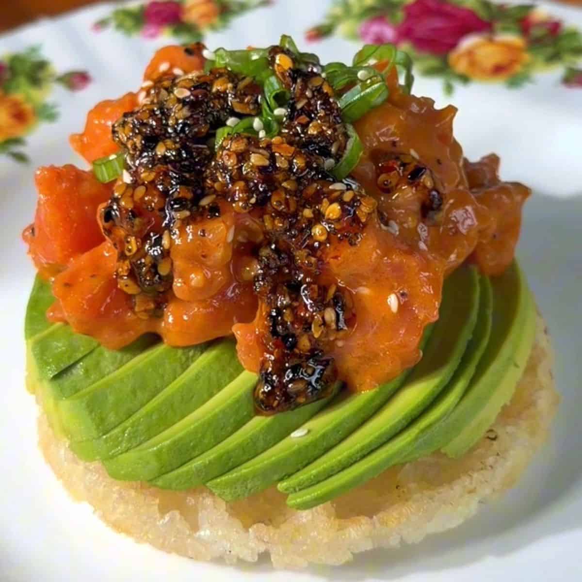crispy rice waffle, made in a mini waffle maker, topped with avocado, salmon, green onion and chili oil
