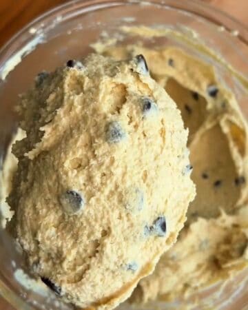 a scoop of high protein edible cookie dough made with almond flour, chocolate chips, maple syrup and protein powder