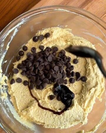 chocolate chips being added to the dough of high protein edible cookie dough