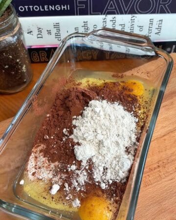 cottage cheese mixture, cocoa powder, oat flour, egg, baking powder, and vanilla in a baking dish, ready to be whisked for high protein molten lava cake