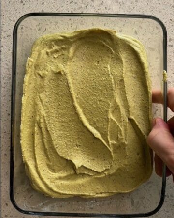 3 ingredient high protein pistachio ice cream being spread into a baking dish getting ready for the freezer