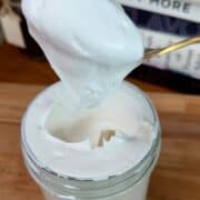 homemade marshmallow fluff on a spoon, overflowing out of a jar