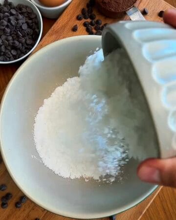 egg whites and powdered sugar whisked to a glossy smooth batter in a white bowl