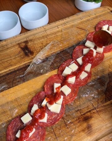 pepperoni, mozzarella, tomato sauce layered on top of rice paper sheets for the making of pepperoni pizza rice paper spiral