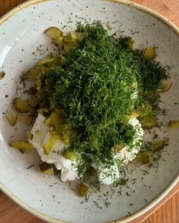 cream cheese greek yogurt and three kinds of chopped pickles mixed together in a bowl for fried pickle dip
