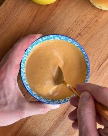 hot honey butter with chili flakes warming in small bowl, being stirred until glossy