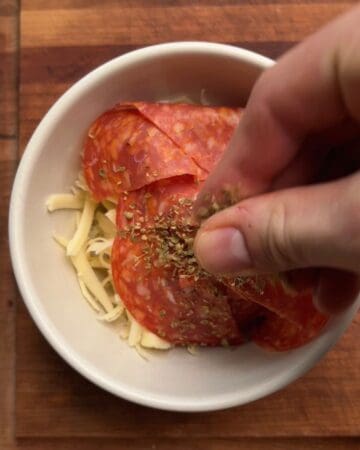 shredded mozzarella and diced pepperoni mixed together in a bowl for pizza pocket filling