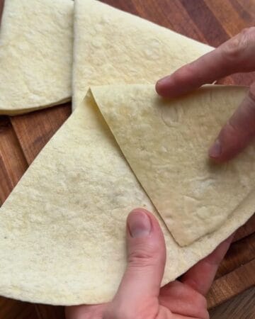 flour tortilla half folded into a cone shaped pocket ready to be filled