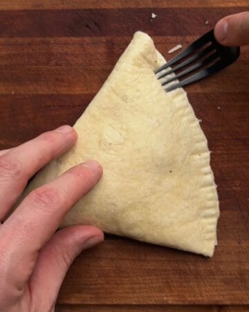 tortilla pizza pocket edges crimped with a fork after brushing with water to seal