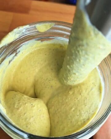 pistachio frozen yogurt mixture being tasted with a spoon before pouring into molds