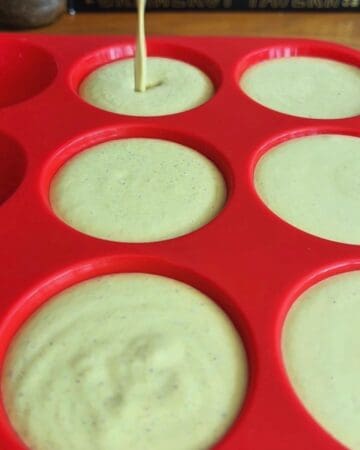 pistachio frozen yogurt mixture being poured into silicone muffin molds