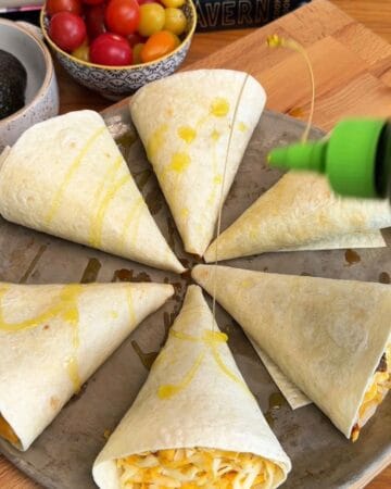 Delicious crispy beef taco cones filled with cheese and a drizzle of olive oil ready to be baked