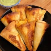 crispy beef taco cones golden and crunchy on a serving board with cilantro jalapeno yogurt dipping sauce