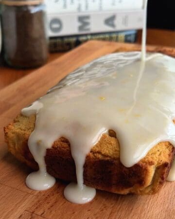 Delicious lemon cake with white glaze on a wooden board.