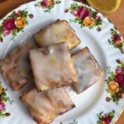 Delicious homemade lemon bars with a sweet glaze on a floral plate.