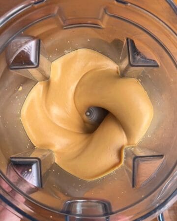 Creamy roasted peanuts blending in a food processor.