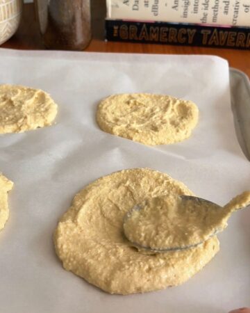 Raw High Protein Pizza Dough dough on parchment paper with a spoon for mixing.