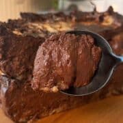 Close-up of a rich s'mores cheesecake cake slice on a spoon.