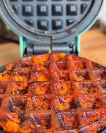 Close-up of crispy sweet potato waffle with cheese in a waffle iron