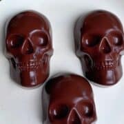 A finished batch of chocolate protein gummy skulls on a white plate, ready to be eaten.